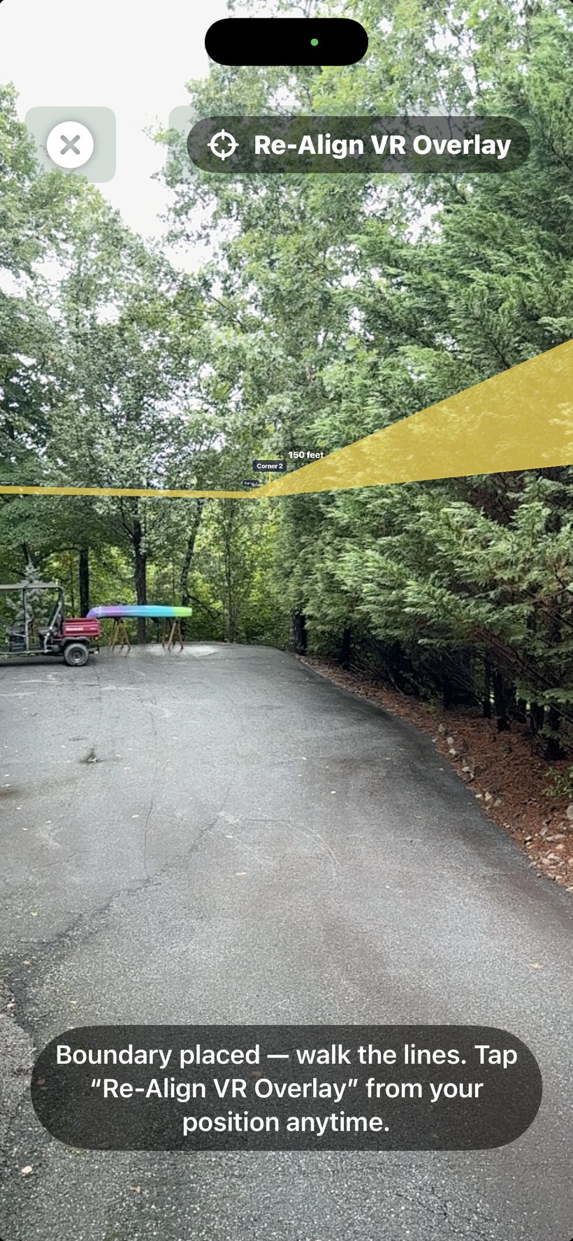 AR view showing the property boundary as a low amber fence laid on the ground, with a copper stake and corner-name flag at each corner and leg distances along the sides