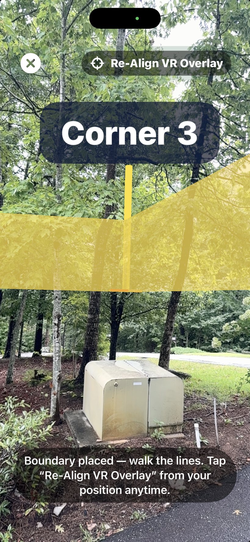 AR boundary mode showing an amber fence line and copper corner stakes with name flags pinned to the ground, with leg distances labeled